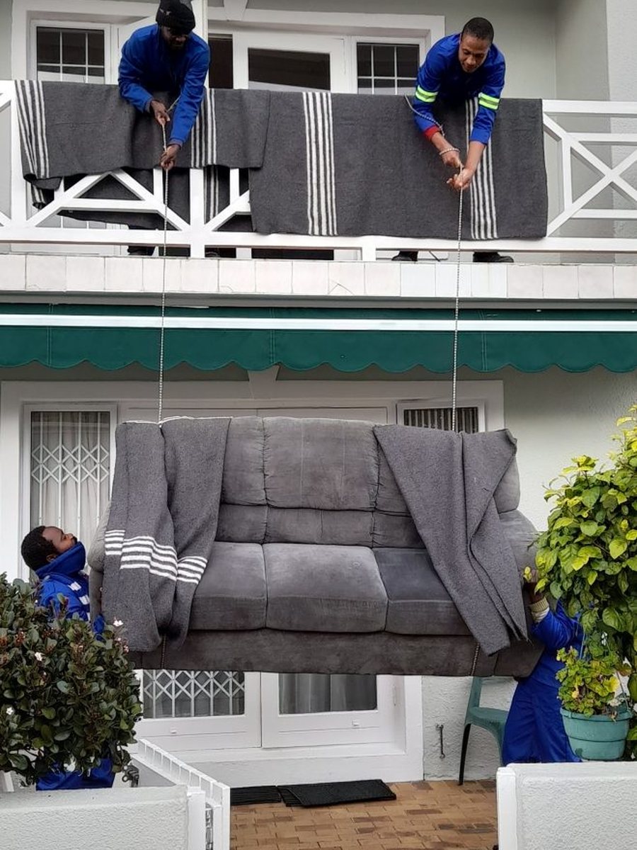 Team lowering a couch from an upper floor